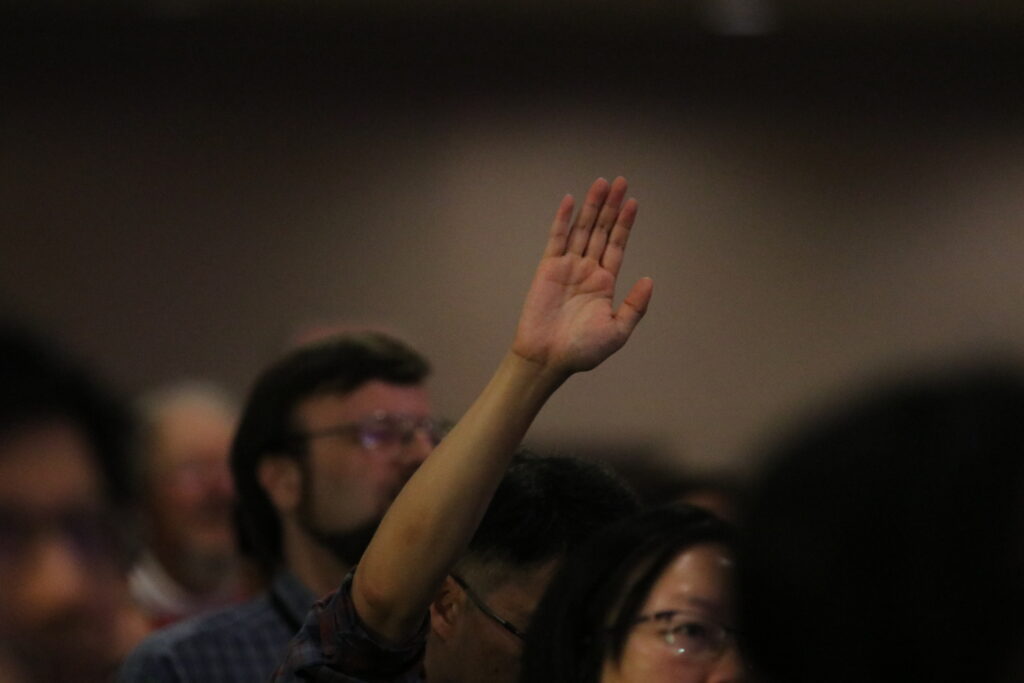 A person lifting up their hand in worship.