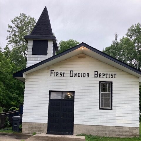 Small white church with steeple; sign says First Oneida Baptist.