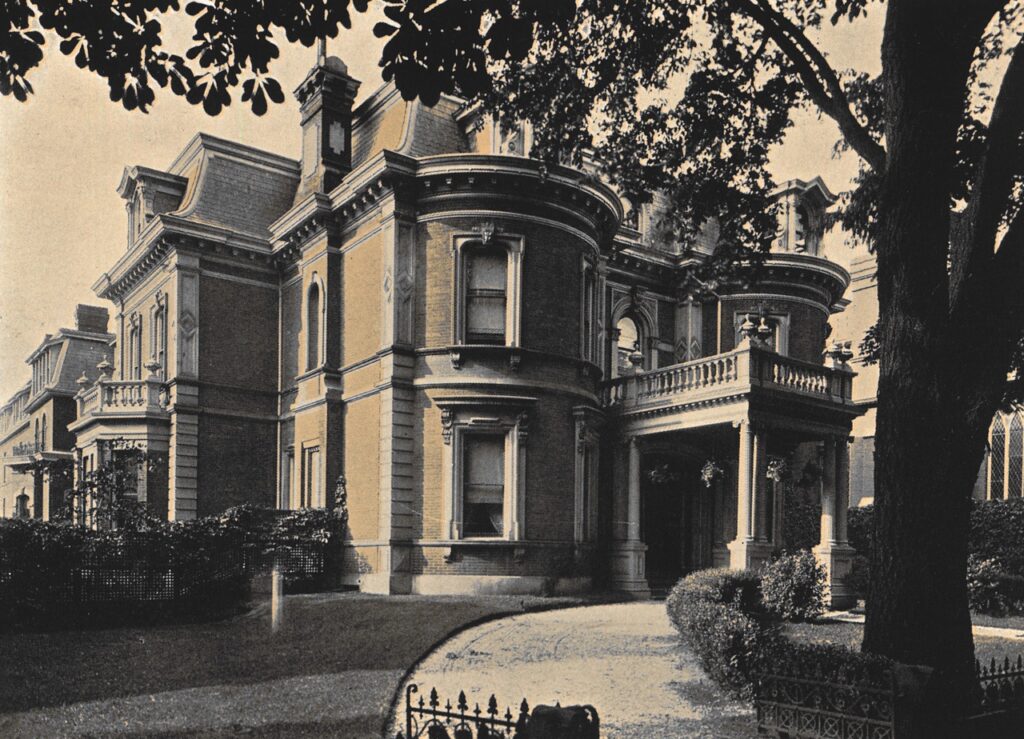 Historic exterior of Moulton College: grand Victorian mansion with mansard roof, columns, and a curved driveway.